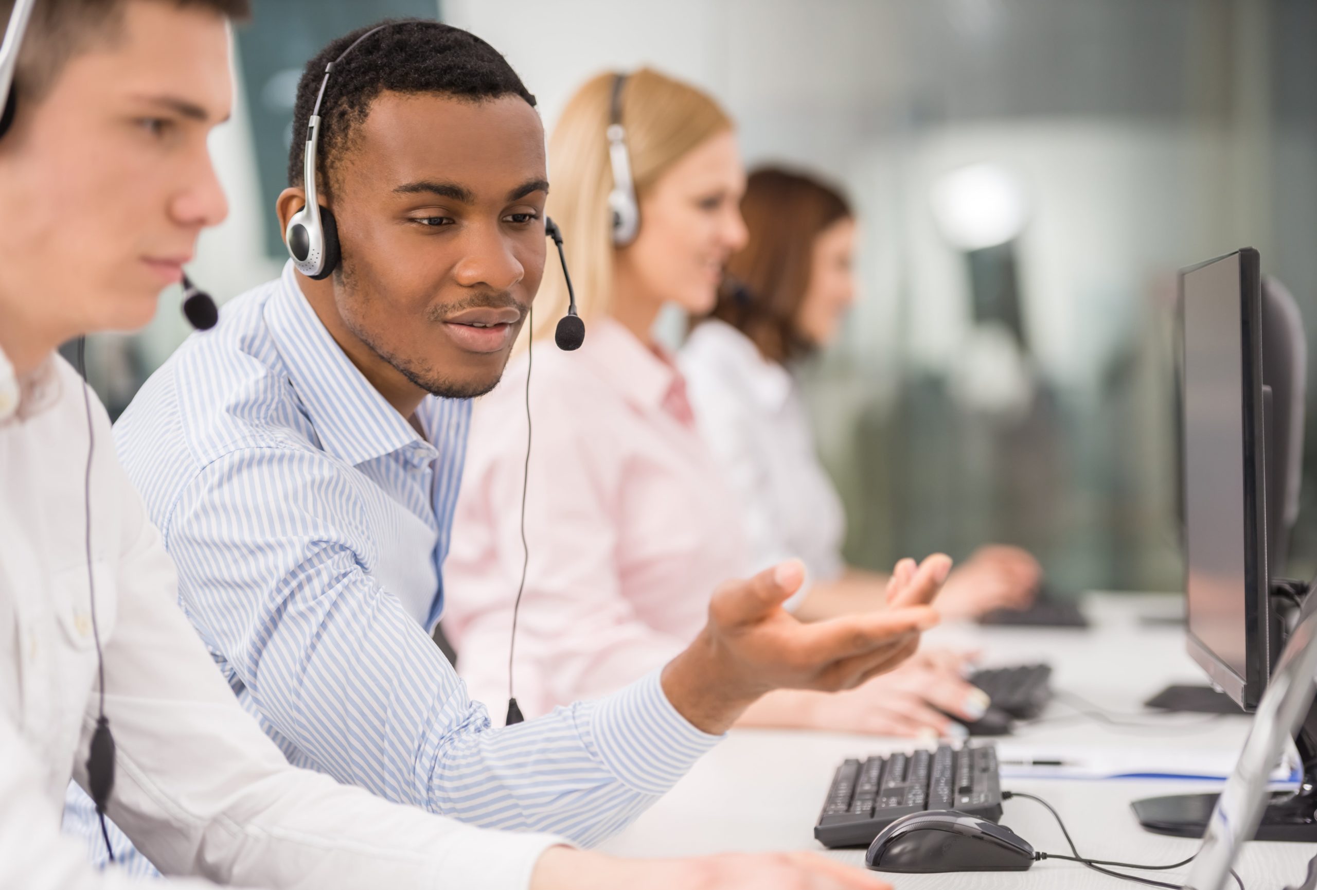 A call centre agent mentoring another agent.