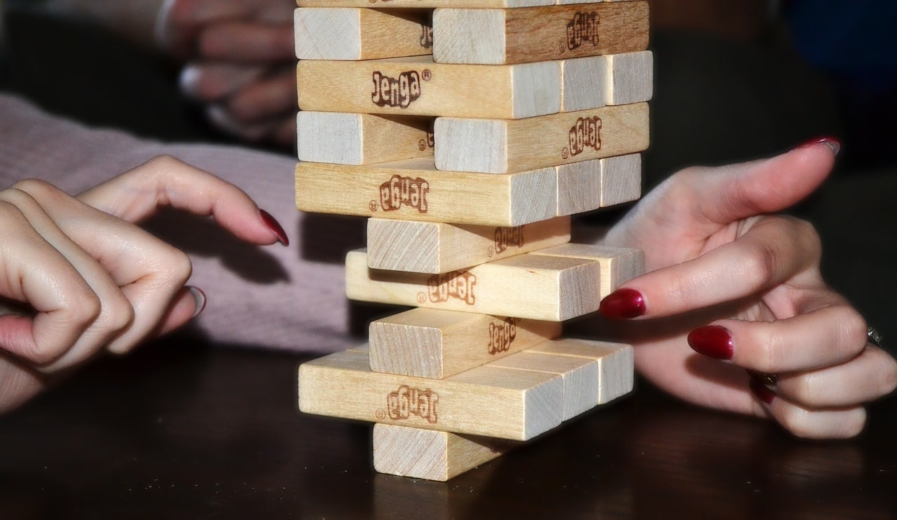 Person taking a piece out of a Jenga stack.